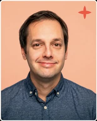 A man in a denim shirt smiling