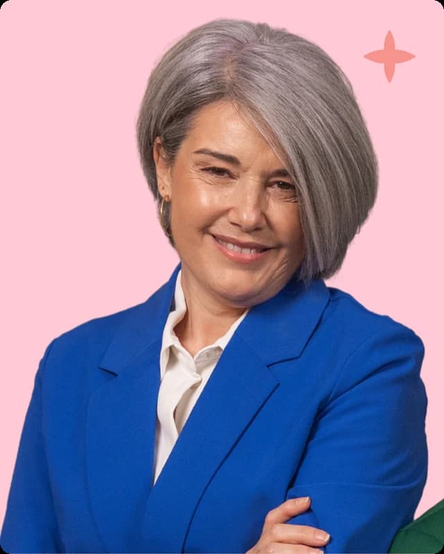 A senior woman in a blue blazer, arms folded
