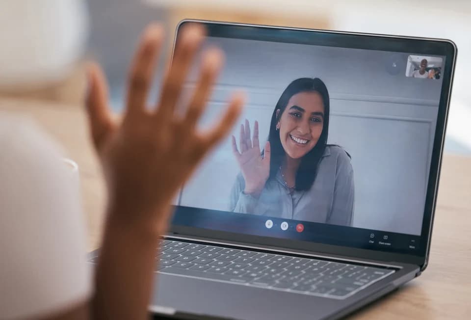 A coaching session on a laptop screen, coach waving hello
